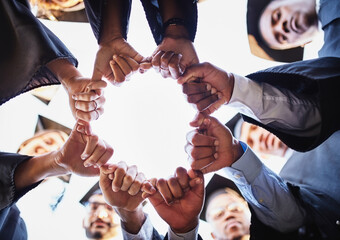 Graduation, fist bump and students in circle at university for ceremony, celebration and academic achievement. College degree, friends and below of hands of people for education, learning or studying