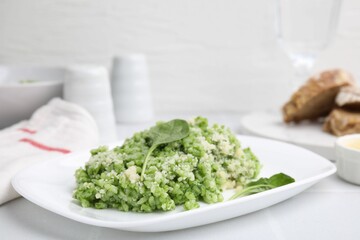 Delicious spinach risotto with parmesan cheese on white tiled table