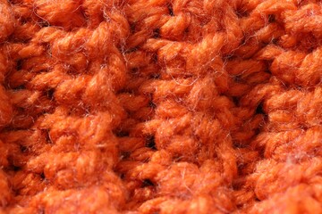 Texture of orange knitted fabric as background, closeup