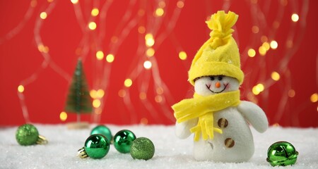 Cute decorative snowman and Christmas balls on artificial snow, space for text