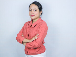 smiling confident business woman wearing pink shirt, looking at camera, standing arms crossed.