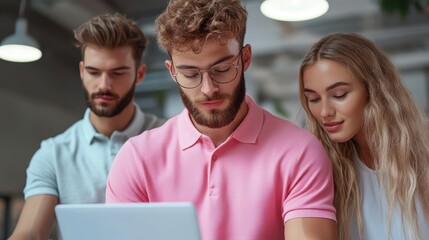 A group of young professionals collaborating on a laptop in a modern workspace, showcasing teamwork and digital communication.