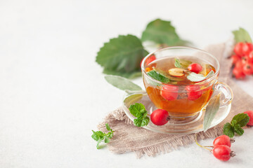 Hawthorn tea with mint and sage leaves in a glass  cup on the table. Vitamin health drink. Copy space