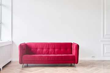 Modern home decor. There is a place to copy. The stylish interior of the living room of a modern apartment with a red sofa. An empty space for your design. High quality photo