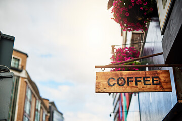 Obraz premium Coffee shop, city and wood sign for advertising, information or marketing store outdoor. Cafe, banner and board on restaurant building for design, commercial news and rusty public notice for retail