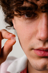 Fototapeta premium Dermatological acne patches or stickers to absorb excess fluids from pimple. Quick dealing with pimples without squeezing. Man is applying acne pimple patch on his face to heal from zits.