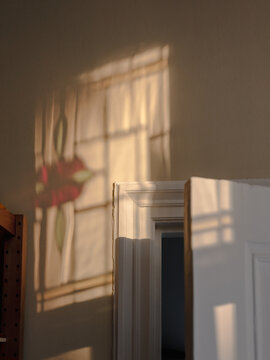 Light shines through a leaded glass window onto a wall of a 100 year old apartment in The Hague, The Netherlands.