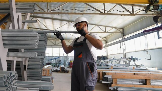 Indian factory worker checks the metal profile