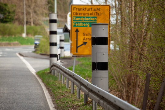 Drei moderne Blitzer mit zwei und vier Ringen hintereinander auf einer Strasse im Taunus.