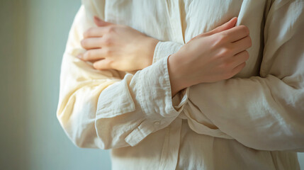 A person wearing a longsleeve shirt, carefully rolling up the sleeves to reveal irritated and red skin underneath, hidden discomfort, dermatitis awareness