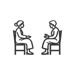 Two elderly women sitting in chairs facing each other