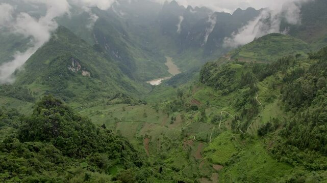 Aerial view of tu san canyon with nho que river and lush rice terraces surrounded by majestic mountains, meo vac, Vietnam.