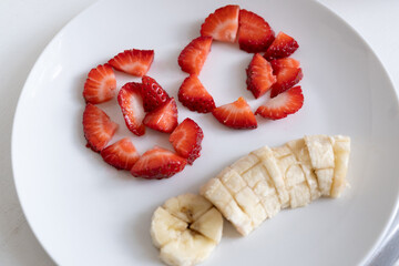 fresas picadas organizadas con la palabra GO y plátano