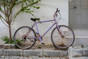 Purple retro bicycle standing on a sidewalk