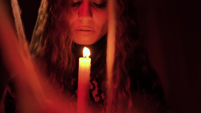 Art video fantasy gothic woman holding and blow-out candle. evil danger. Girl in black dress in dark room night
