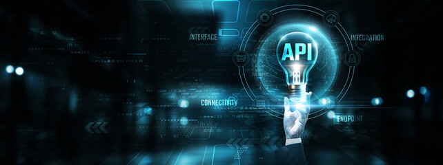 API : Hands of businessman holding light bulb and API with data network digital technology. Integration, connectivity, automation, innovation. © AD