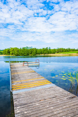 Wooden pier on shore of Pobondzie lake in spring season, Suwalski Landscape Park, Podlasie, Poland