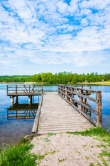 Fototapeta premium Wooden pier and beach on shore of Pobondzie lake, Suwalski Landscape Park, Podlasie, Poland