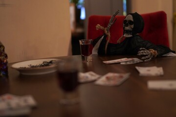 skeleton sitting at table playing cards . interior decoration concept for autumn holiday halloween party