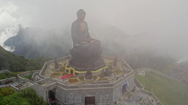 Aerial view of fansipan mountain with a majestic buddha statue shrouded in fog, sa pa, Vietnam.