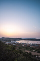 Beautiful sunset landscape in Mellieha Bay with some boays in Malta Island, Mediterranean Sea