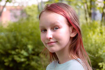 Fototapeta premium Portrait of a cute smiling girl of 9 years old against the background of a summer park