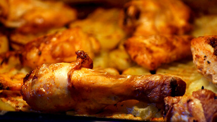 Fried chicken with potatoes in oven . High quality photo