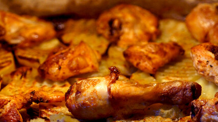 Fried chicken with potatoes in oven . High quality photo
