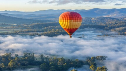 Naklejka premium A hot air balloon floating above a valley covered in fog, AI