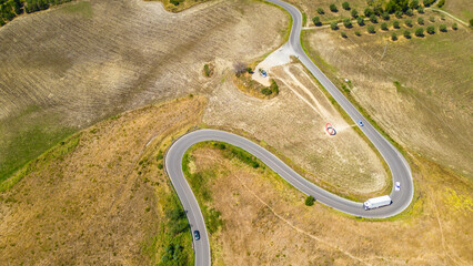 An aerial view of L'Anello near Volterra in Tuscany, Italy, captured by a drone. This scenic area is known for its lush, rolling hills and picturesque landscapes typical of the Tuscan region