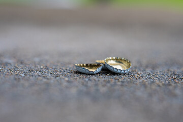 Small pile of bottle caps on asphalt.