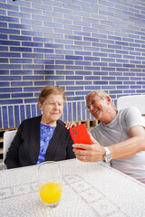 Elderly mother and her son looking at mobile. Family life