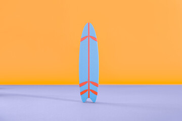 Mini surfboard on blue table against orange background
