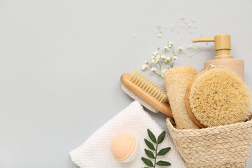 Basket with different bath supplies on grey background