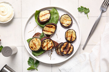 Toasts with delicious grilled eggplants on light background