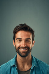 Happy, smile and portrait of man in studio with positive attitude, confidence and pride. Handsome, attractive and isolated person with joy, cheerful and excited expression on gray background