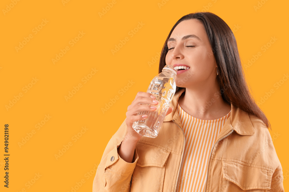 Wall mural young woman with bottle of water on yellow background