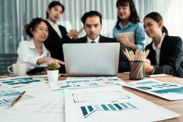 Focus financial data dashboard paper by business intelligence display graph, chart and statistic report on office table with blurred business people working in background. Habiliment
