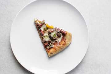Overhead view of chicken pizza slices on a white plate, top view of beef and mushroom pizza slice