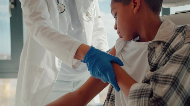 Black boy calmly waiting for end of vaccination procedure