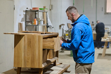 Close Up of Worker Carefully Cutting and Planing Wooden Pieces for Furniture in Wood Industry