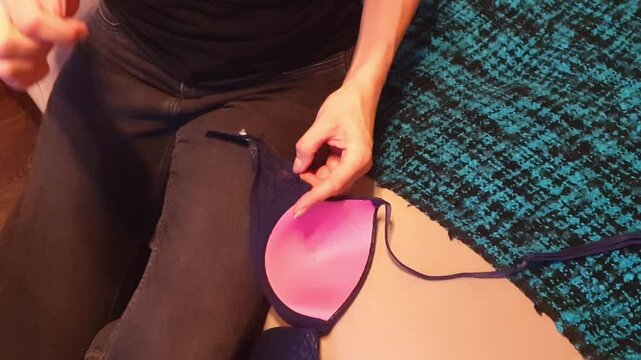 Slow motion footage of the woman with beautiful hands stitching or sewing delicate lingerie fabric. Craft
