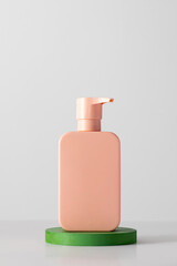 A pink mock-up of a cosmetic product with a place for a logo on the podium. 