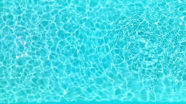 Blue water in the swimming pool with light reflections. Slow motion
