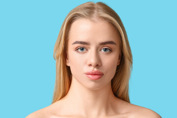 Young woman with beautiful lips on blue background