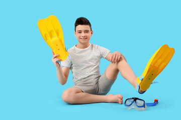 Cute little happy boy with snorkeling mask and flippers on blue background © Pixel-Shot