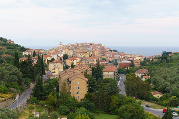 Fototapeta premium A Coastal Italian Town Nestled Amongst Green Hills on a Cloudy Day