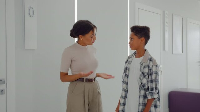 Supportive mom encouraging son entering cabinet of doctor