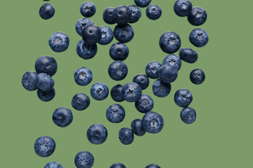 Flying fresh blueberries on green background