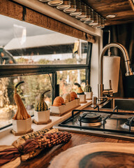Autumn Scene Vanlife Close Up Interior with Window. Decorated with Pumpkins, Gourds, Corn on Kitchenette Fall Foliage. Camper Van Travel Influencer